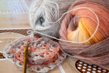 Close-up, grey and multi colored yarns and crochet needle. 