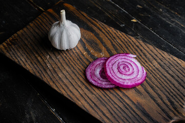 Onion, garlic and salt on a wooden cutting board. Top view.