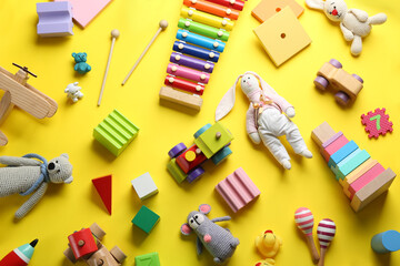 Flat lay composition with different toys on yellow background