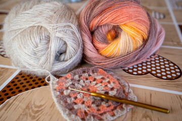 Close-up, grey and multi colored yarns and crochet needle. 