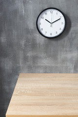 wall clock and desk near concrete background
