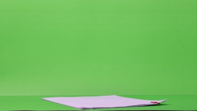 4K Stop motion of close-up stack overload document report paper with paperclip place decrease on green background, business and education concept footage paperless used. 