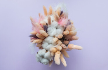 multi-colored dried flowers, dried flowers in the working space of the florist. Bouquet, comfort, Floristics. colorful dry plants, colored feathers, down on a lilac background. Copy space.