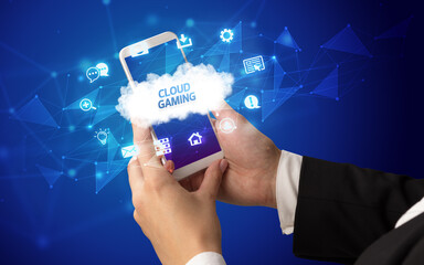 Female hand holding smartphone with CLOUD GAMING inscription, cloud technology concept