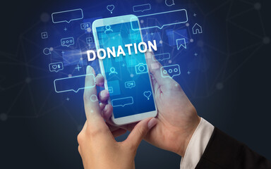 Female hand typing on smartphone with DONATION inscription, social media concept
