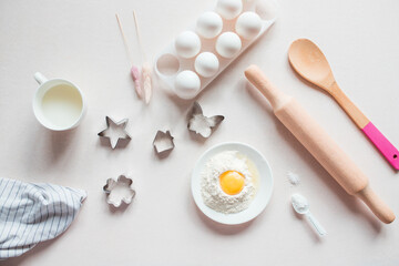 Fototapeta na wymiar Baking ingredients. Eggs, flour, milk, whisk, rolling pin, bakeware on a white background, top view. cook's workplace in the kitchen. beautiful dishes. Copy space. homemade cookies. Cooking background