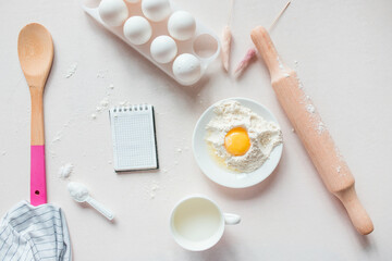Ingredients for baking on a white, lilac background: eggs, flour, whisk, rolling pin. View from above. Copy space. workplace in the kitchen. Christmas kitchen atmosphere. Frame for cooking