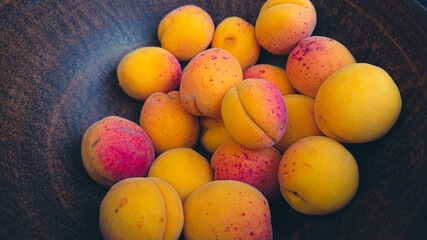 Many apricots in a deep clay plate