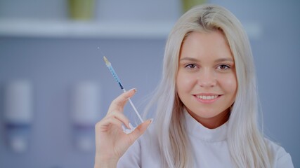 Doctor Or Dentist Close Up Portrait In Hospital Or Clinic Hold Syringe With Blue Vaccine Covid19 Young Blonde Caucasian Confident Attractive WomanMedical Aesthetic Medicine Concept