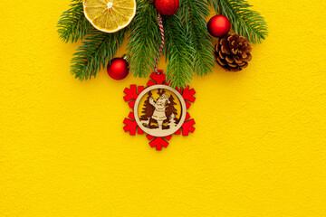 Spruce branch, cones and vintage toys decoration on christmas or new year on yellow background