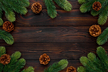 Spruce branch, cones and toys decoration on christmas or new year on dark wooden background.
