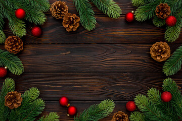 Spruce branch, cones and toys decoration on christmas or new year on dark wooden background.