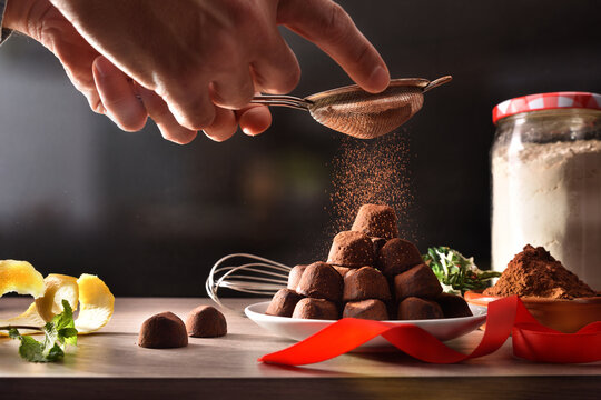 Hands Pouring Cocoa Powder On Freshly Made Chocolate Truffles