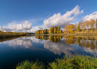 Obraz premium colorful autumn panoramas with yellow trees by the lake, beautiful and colorful reflections in the calm lake water, golden autumn