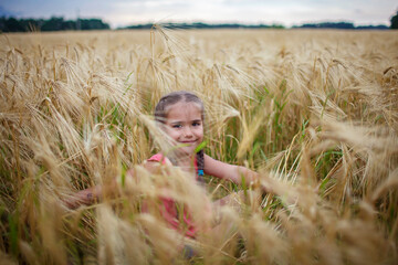 Girl sitting in wheat field, live life to the fullest, freedom, childhood and happiness