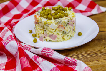 Traditional Russian festive salad Olivier on wooden table