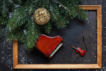 Miniature copies of the piano and violin with Christmas decor and snowflakes. Christmas, New Year's concept. Top view, close-up, wooden frame.