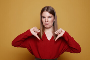 Studio portrait of annoyed and disgusted young European woman wearing stylish clothing expressing...