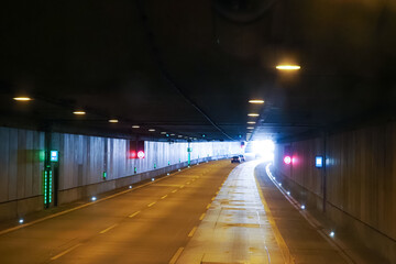 Car tunnel, traffic on the highway. Car drives through the tunnel. Emergency exit from the tunnel, emergency telephone