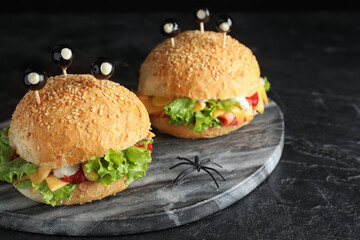 Cute monster burgers served on black table. Halloween party food