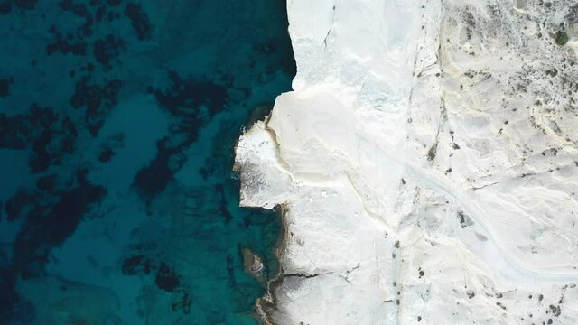 Cinematic aerial drone footage of white rocks and turquoise water on Sarakiniko Beach, Milos Island, Greece