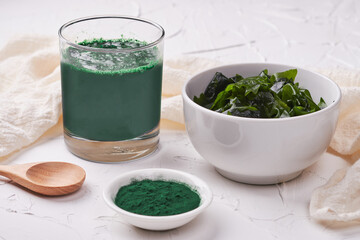 laminaria (Kelp) seaweed and spirulina powder in white bowl background