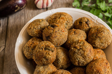 Meatless eggplant meatballs on wooden background.