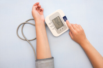 Measurement of pressure. A woman monitors her health by checking the pressure and pulse on her arm....
