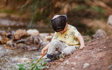 Kid playing with water on the river