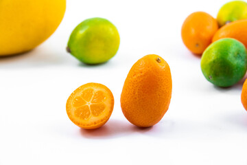 Small citrus kumquat in cut fortunella macro photo on white isolated background