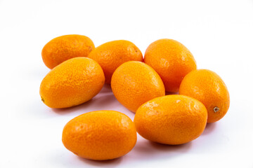 Lots of little kumquats or fortunella on white isolated background