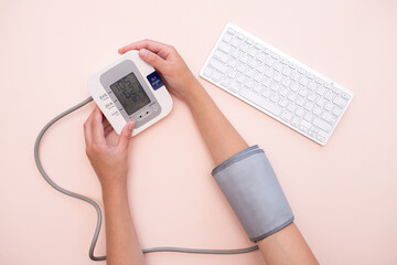 Measurement of pressure. A woman monitors her health by checking the pressure and pulse on her arm....