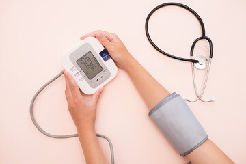 Measurement of pressure. A woman monitors her health by checking the pressure and pulse on her arm....