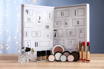 Christmas advent calendar with perfumes and makeup products on table