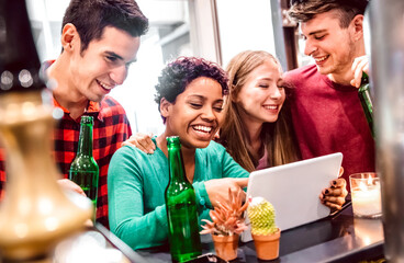 Multiracial milenial friends having fun with laptop at modern coworking space - Technology concept with guys and girls enjoying time together - Bright vivid filter with focus on african american woman