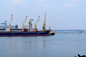 A ship is being loaded near the pier in the port.
