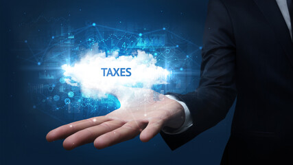 Hand of Businessman holding TAXES inscription, successful business concept