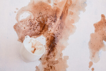 Fototapeta premium Spilled coffee on a white background. the coffee stain. A Cup of coffee spilled. the concept of carelessness clumsiness or accident. 