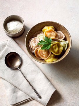 Traditional colourful pelmeni, ravioli, dumplings filled with meat in bowl, russian kitchen.