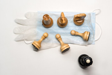 wooden chess pieces on a medical mask. Black's Queen is watching