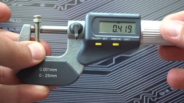 Engineer working with precise micrometer with digital display for quality control. Close up horizontal video of accurate measuring instrument. Micrometer tool showing the exact diameter and thickness.