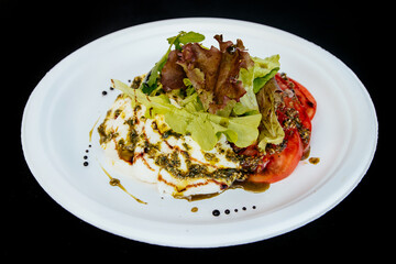 Vegetable salad with tomato cheese, on a white plate, isolate.