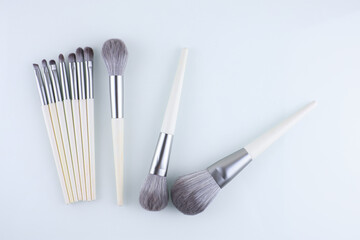 makeup brushes scattered on a white background