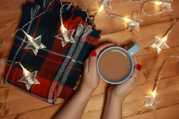 women's hands warm on a mug of hot chocolate milk