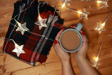 women's hands warm on a mug of hot chocolate milk