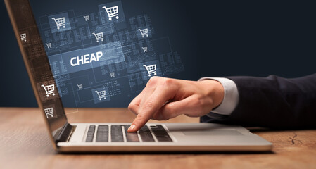 Businessman working on laptop with CHEAP inscription, online shopping concept