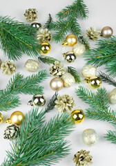 golden christmas balls, golden cones and branches of christmas tree on light background
