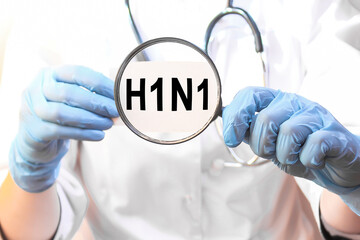 The doctor's blue - gloved hands show the word H1N1 - . a gloved hand on a white background. Medical concept. the medicine
