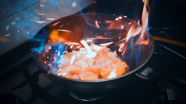 Open fire in a skillet the apple and orange are fried. home kitchen