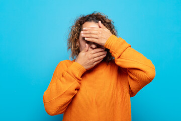 middle age woman covering face with both hands saying no to the camera! refusing pictures or...